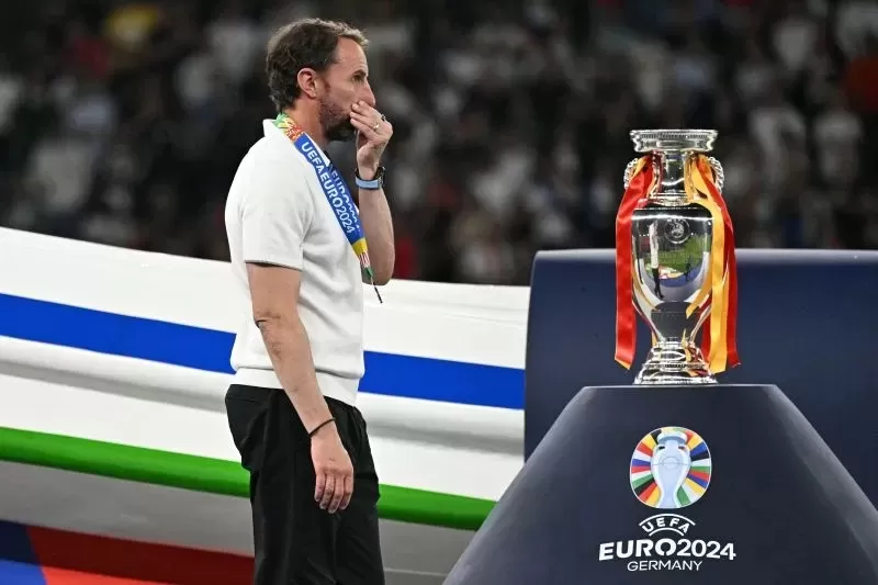 Pelatih timnas Inggris Gareth Southgate berjalan melewati trofi Piala Eropa setelah usainya pertandingan final Euro 2024 antara Spanyol dan Inggris di Stadion Olimpiade, Berlin. (AFP) 